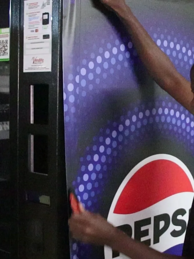 Pepsi vinyl panel being positioned on a vending machine
