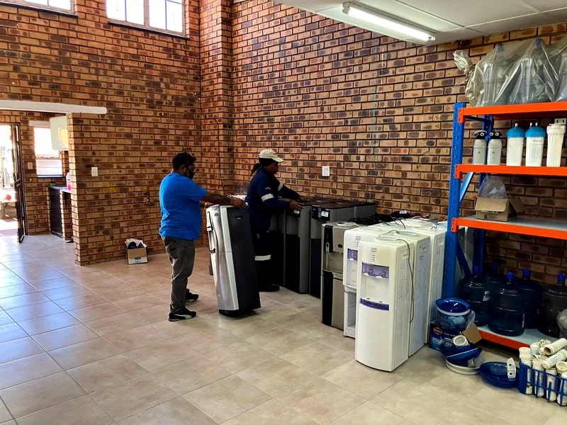 Technicians moving coolers in the store room