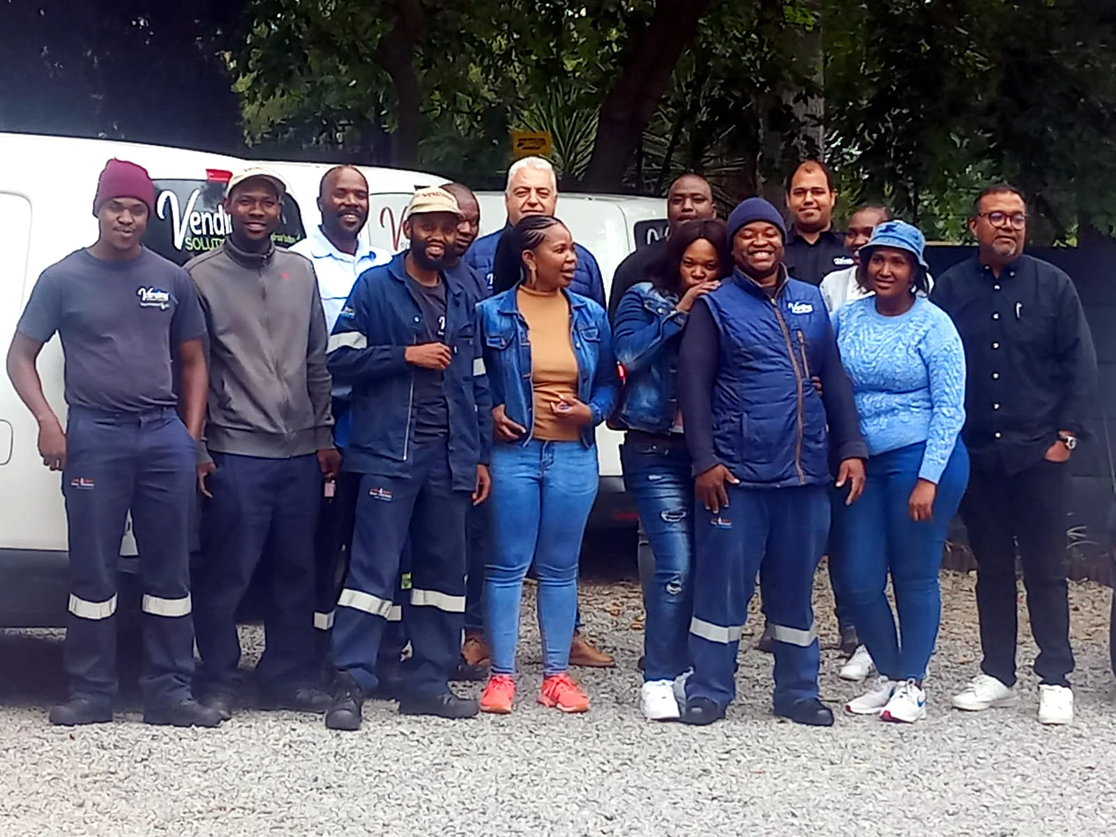 The Vending Solutions team standing together in front of the branded service fleet at head office