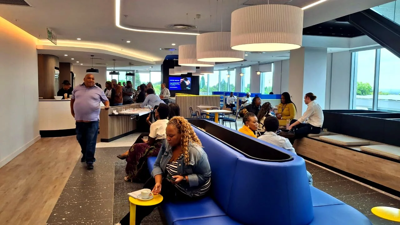 Modern staff cafeteria and break area with teams relaxing over coffee