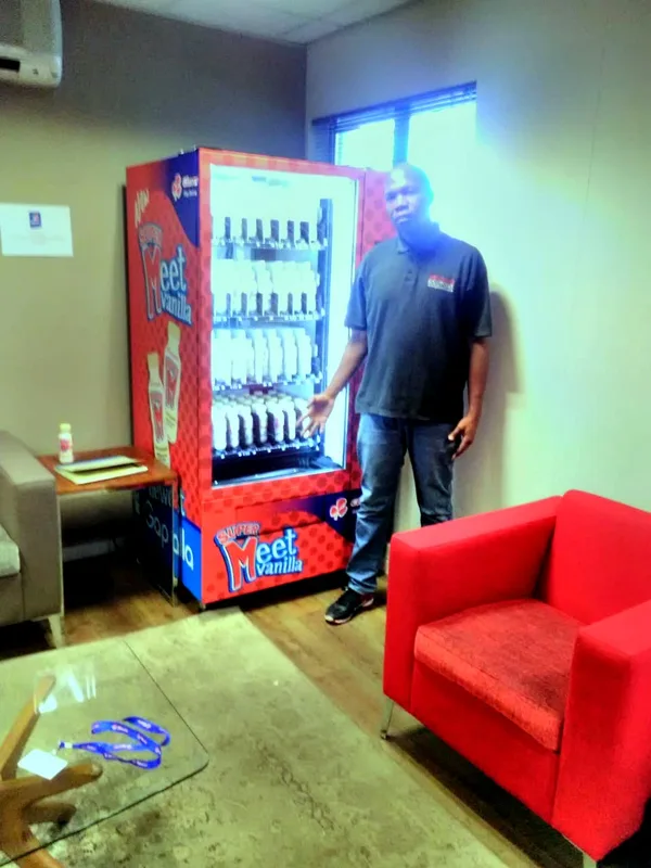 A new owner beside his chilled dairy machine