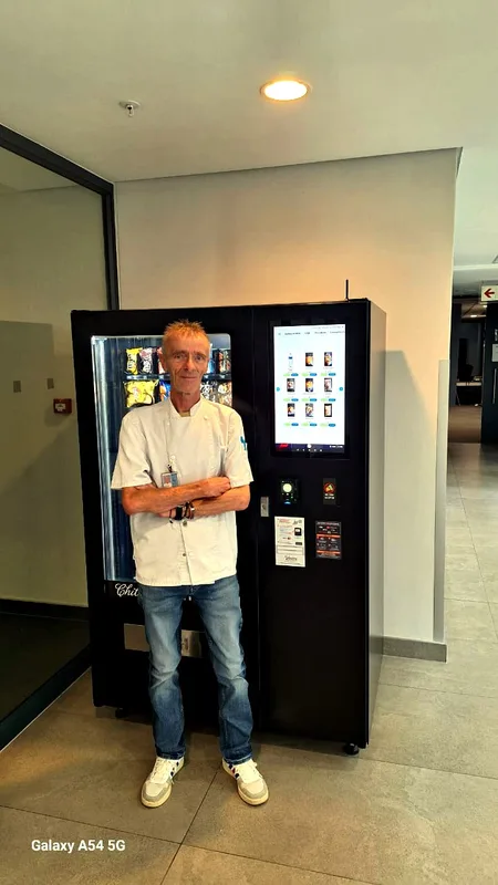 A new owner beside his touchscreen combo machine