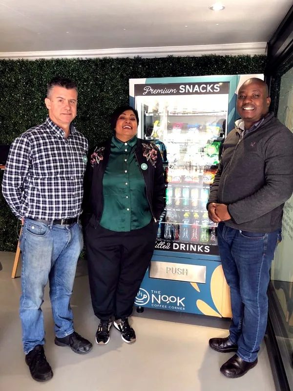 Owners with the machine they run at their cafe