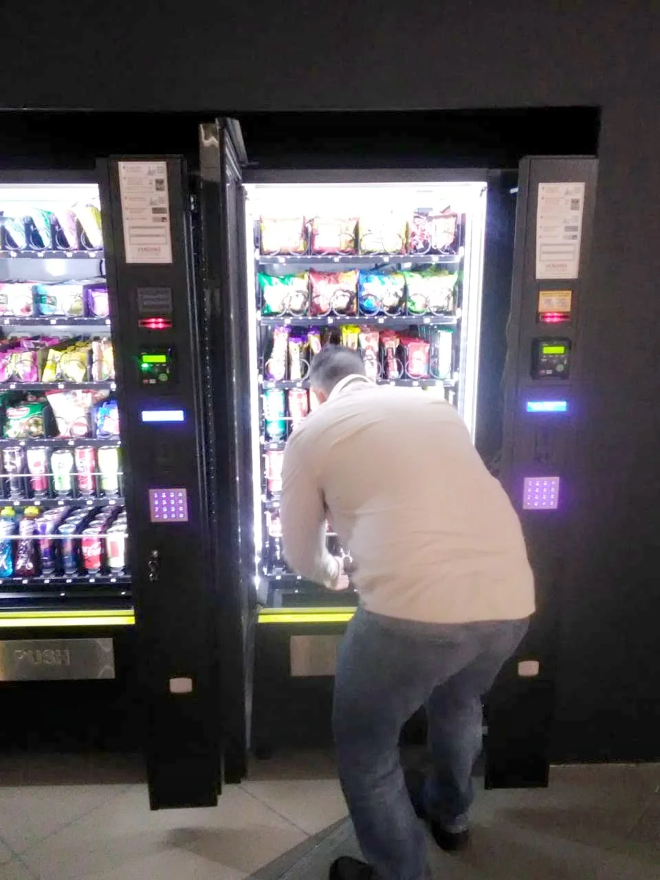 Vending Solutions operator restocking a lit snack and drink machine